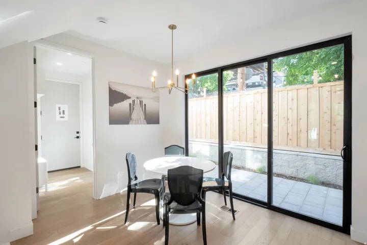 Dining area featuring wide plank wood-finish flooring and a contemporary chandelier
