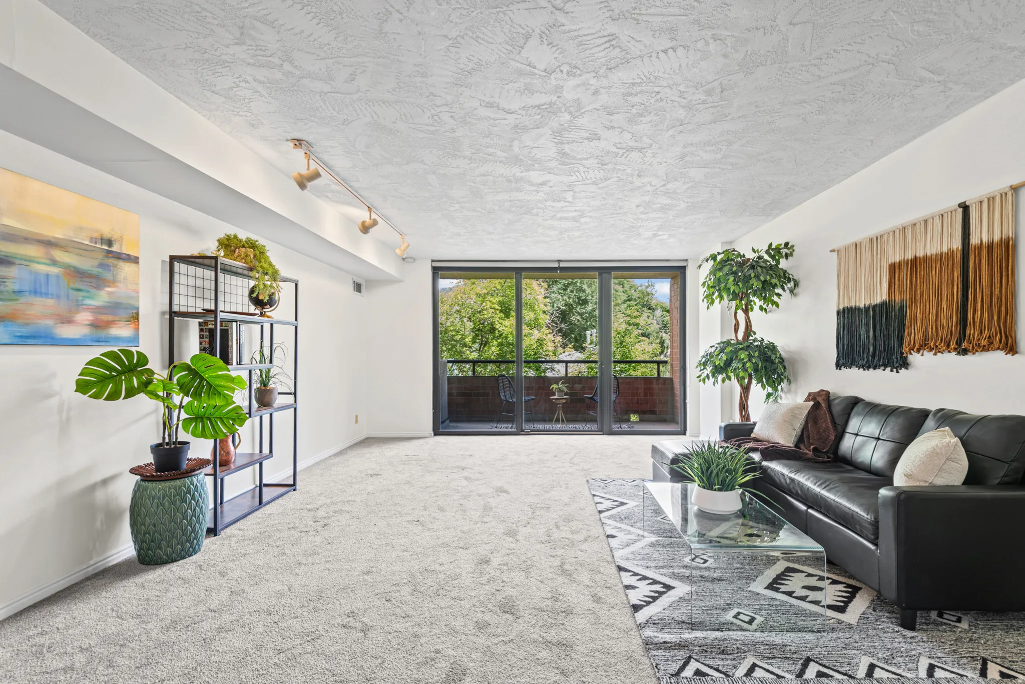 Expansive living space featuring plush carpeting and a textured ceiling