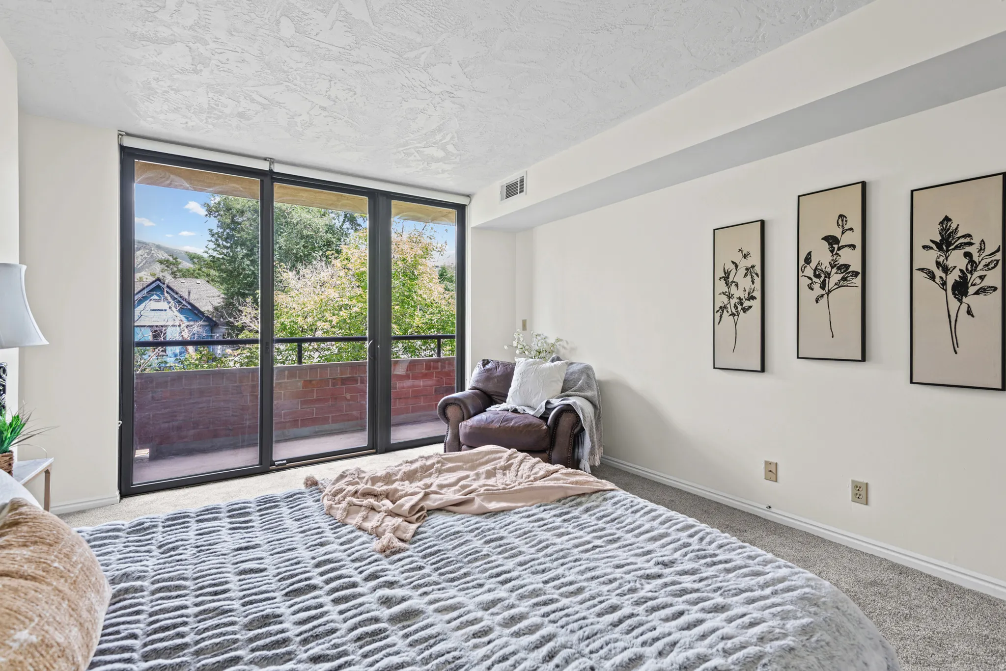 Wall-to-wall sliding glass doors opening to a private balcony