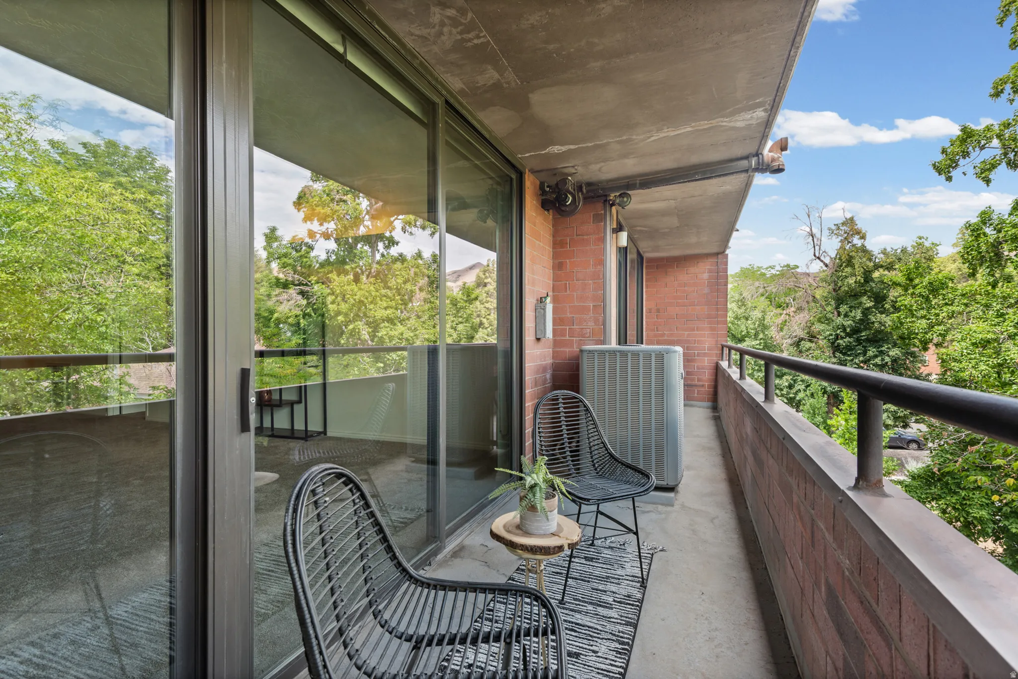 Private balcony featuring a concrete floor and a brick exterior wall