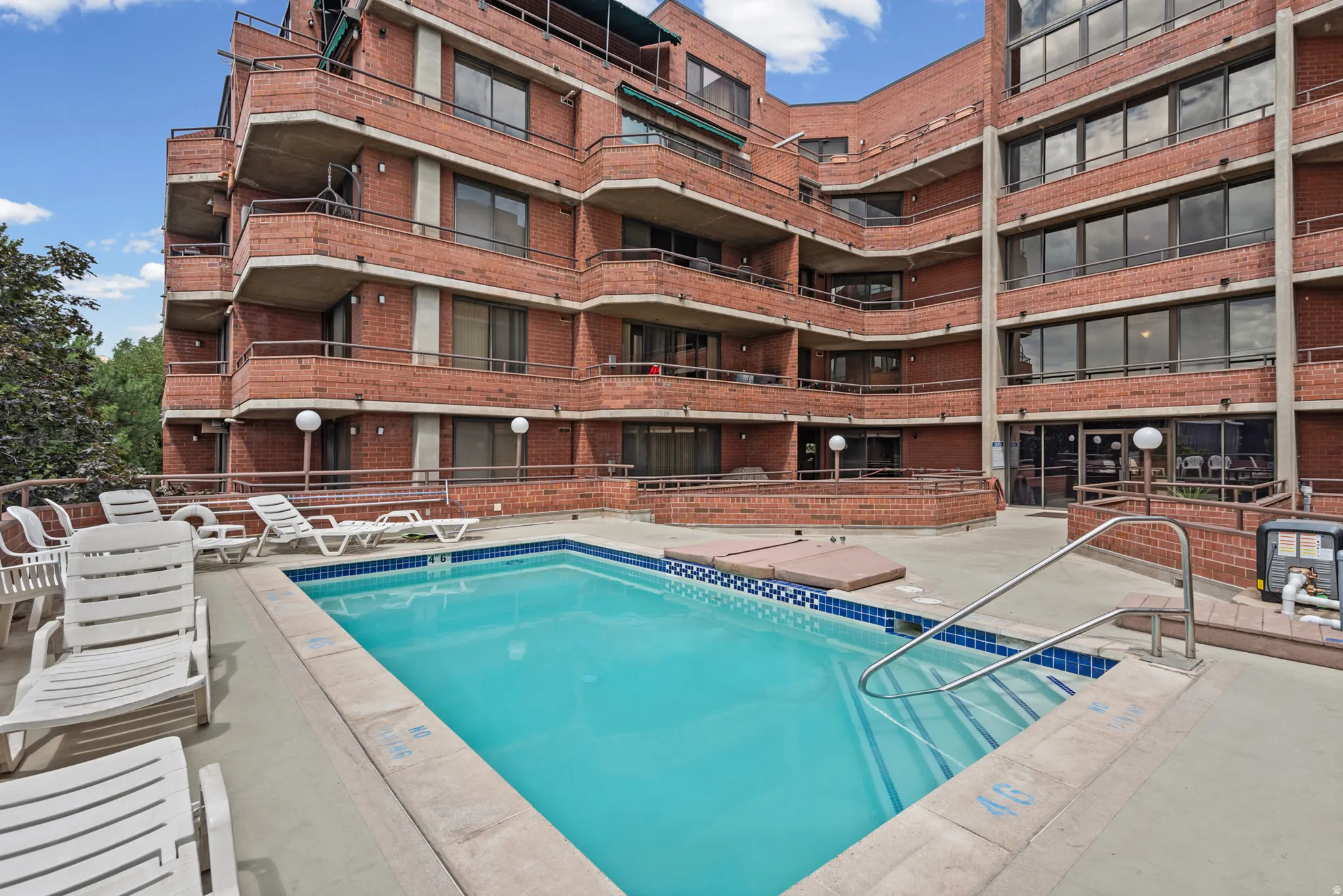 Outdoor pool with a blue tile border and metal handrails