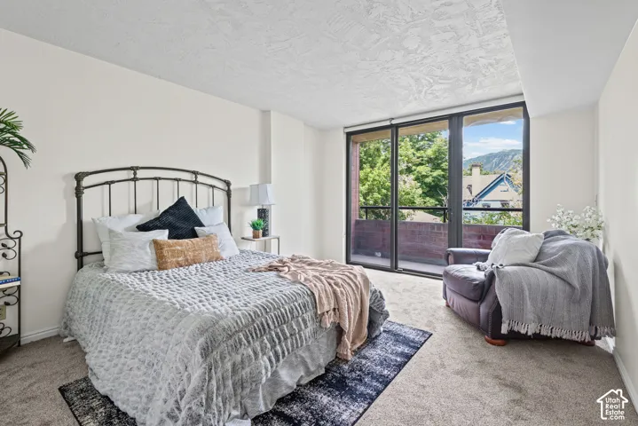 Spacious room featuring a floor-to-ceiling glass sliding door, providing access to a private balcony