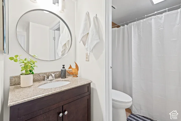 Bathroom featuring a dark wood-finish vanity with a granite countertop, undermount sink, and chrome faucet