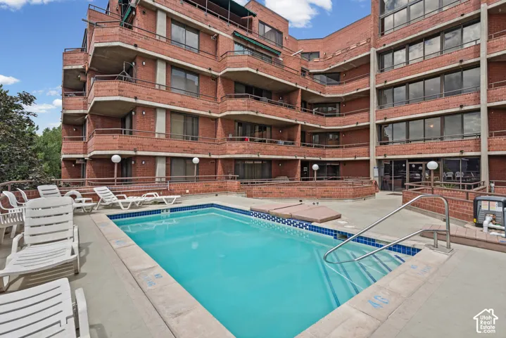 Outdoor pool with a blue tile border and metal handrails