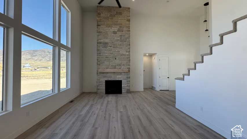 Vaulted ceiling great room with a stone-clad fireplace and wood mantle