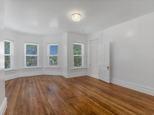 Room with wood-finish flooring and a white color palette