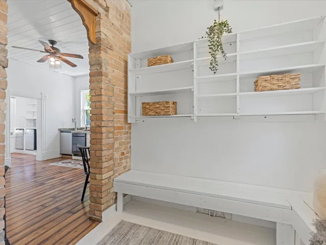 Built-in shelving and bench seating complement the exposed brick archway