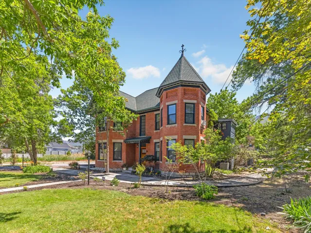 Brick exterior featuring a prominent turret with a dark shingle roof and decorative finial