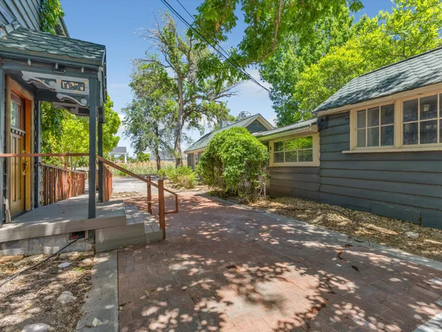 Outdoor brick patio featuring a covered porch entrance with decorative trim