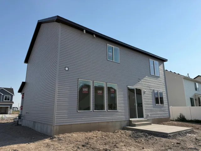 Two-story residence featuring gray horizontal siding and a dark roofline