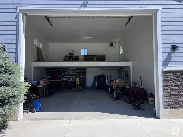 Shop Garage - Two-story garage featuring a light blue siding exterior with stacked stone accents