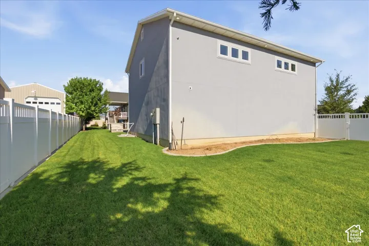 Expansive green lawn with vinyl fencing enclosing the property perimeter