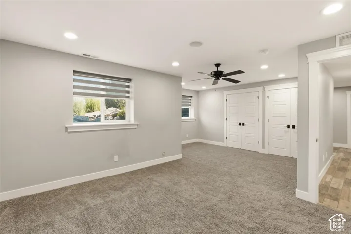 Spacious room featuring neutral carpeting, recessed lighting, and a ceiling fan