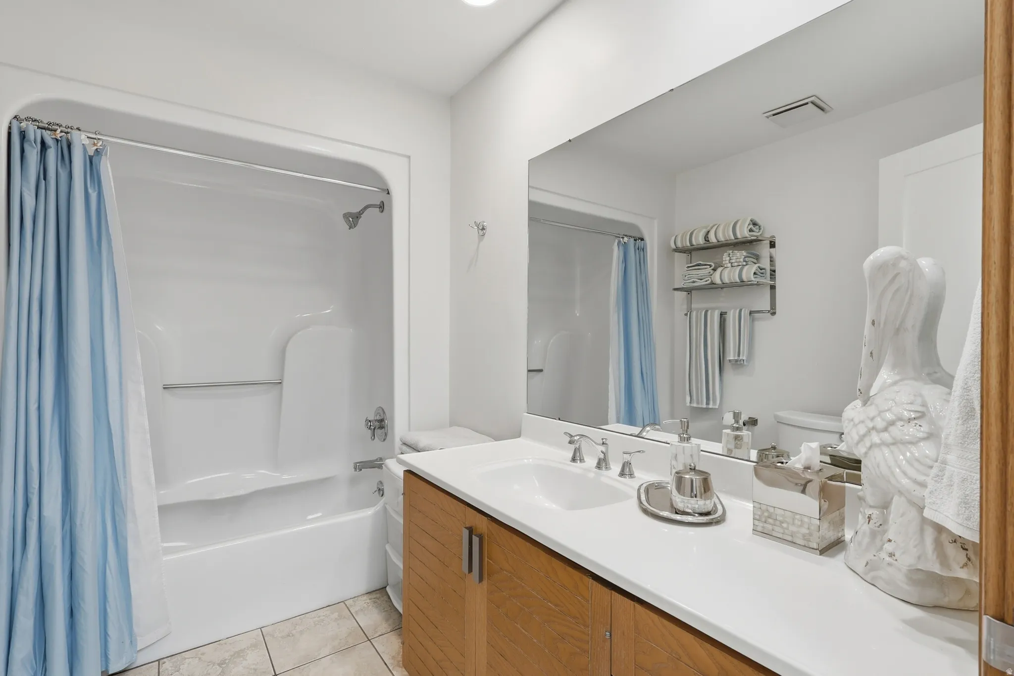 Bathroom #3 featuring a tub/shower combination, a large vanity with a white countertop and integrated sink, a wood-finish cabinet, and a large wall-mounted mirror