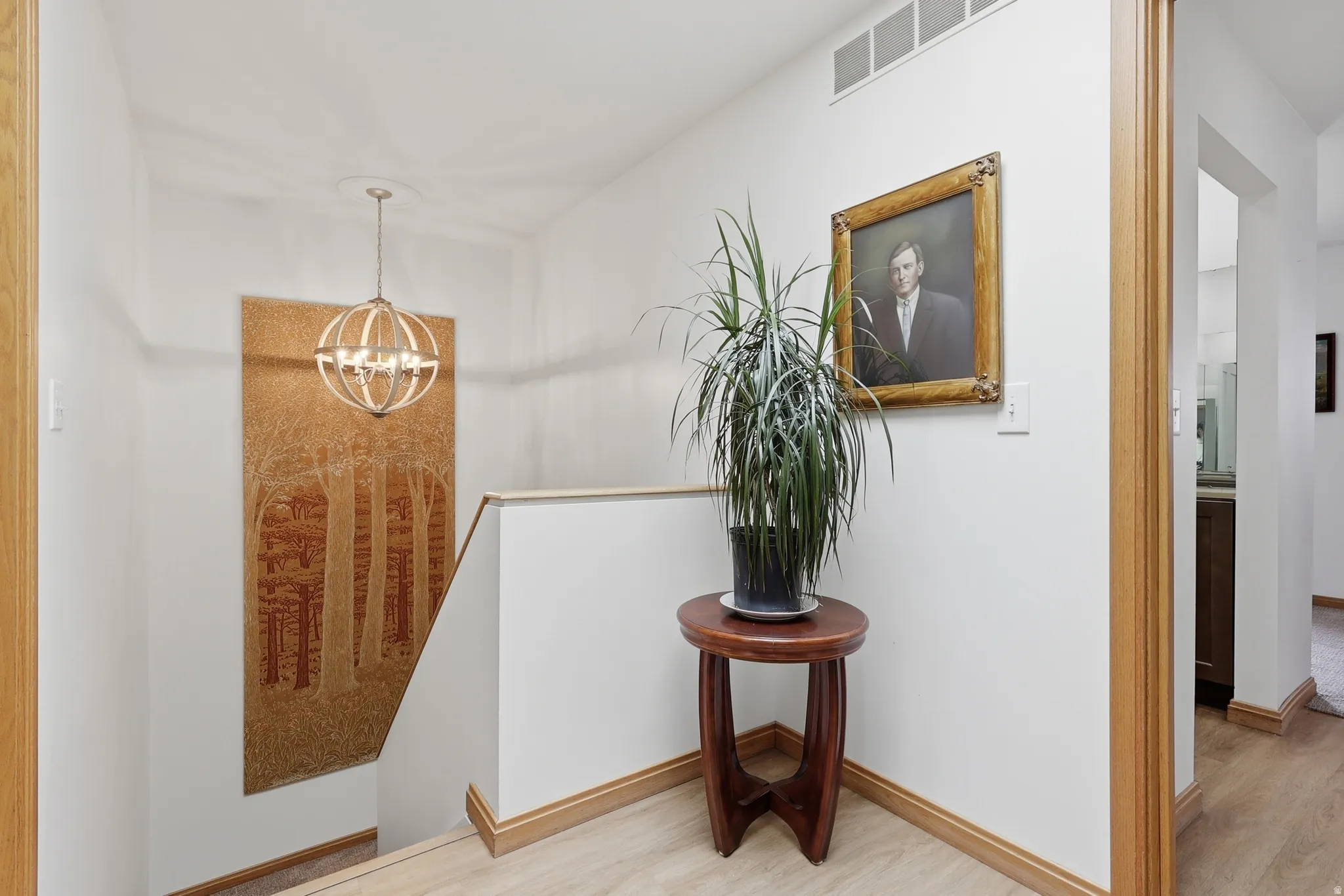 Stairwell featuring a contemporary spherical chandelier, and light wood trim,.