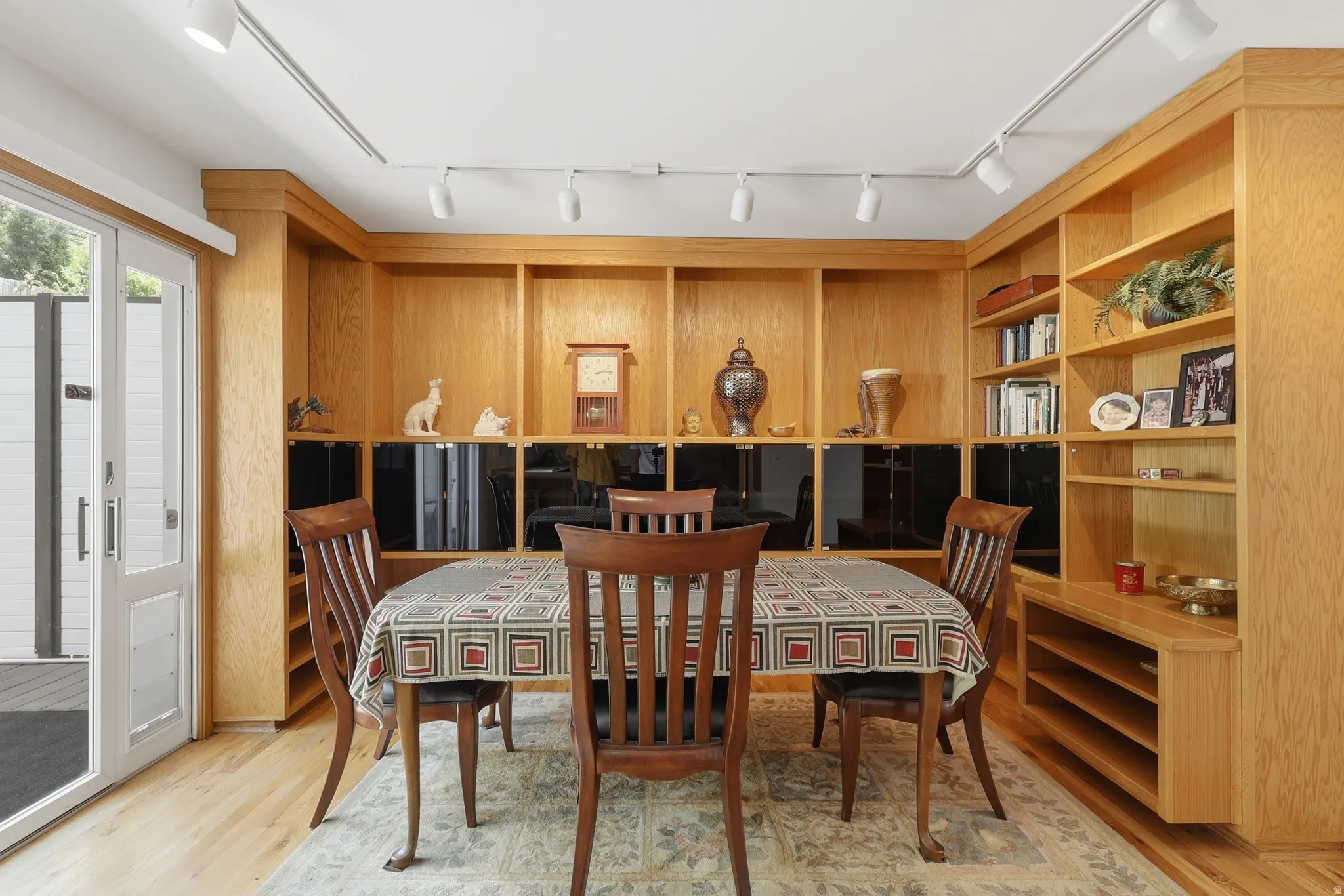 Built-in blonde wood cabinetry with open shelving and enclosed storage