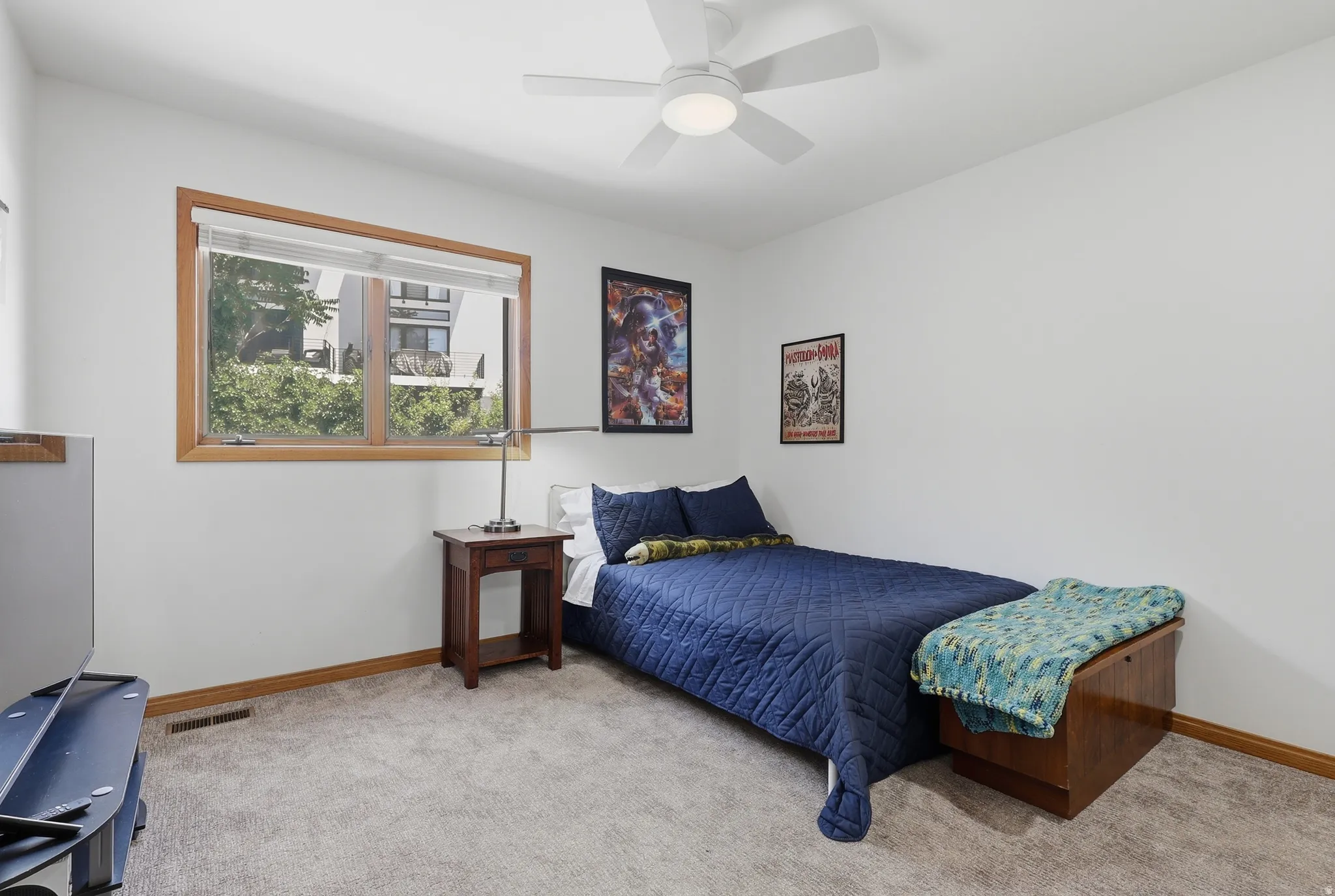 Bedroom #2 features a white ceiling fan with integrated lighting, a wood-trimmed window and spacious closets.