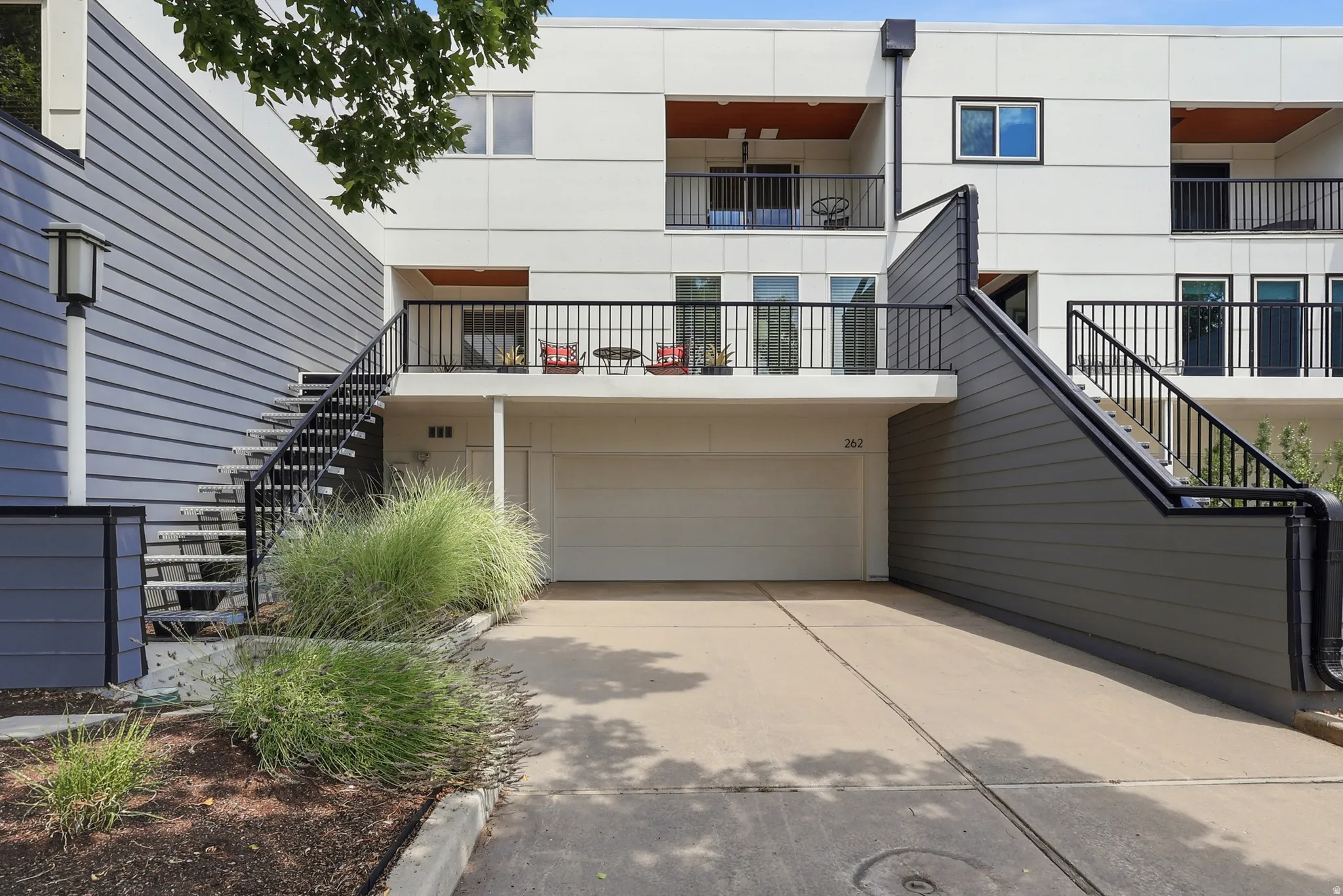 Modern multi-story building featuring light-colored siding and dark horizontal paneling