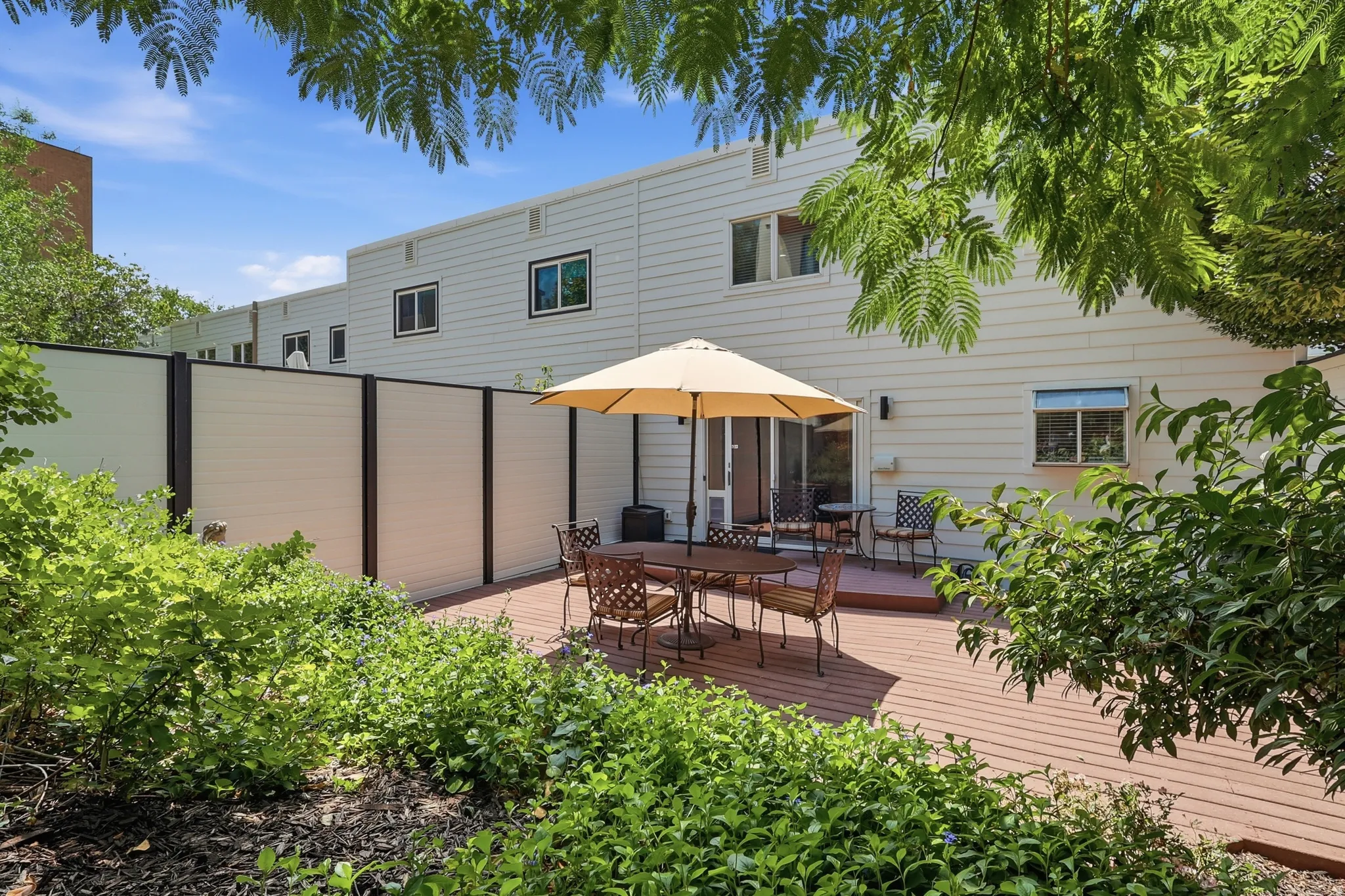 Spacious outdoor deck with surrounding planted landscaping