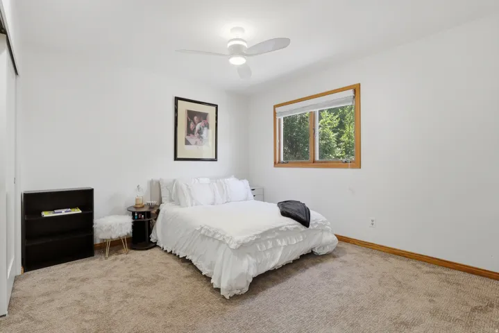 Bedroom #3 features a ceiling fan with integrated lighting, a wood-trimmed window, white window blinds, and ample closet space.