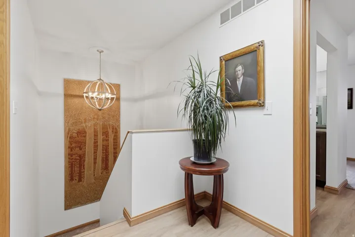 Stairwell featuring a contemporary spherical chandelier, and light wood trim,.