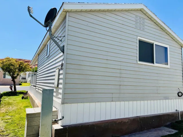 Light-colored horizontal siding with a white trim window and a peaked roofline