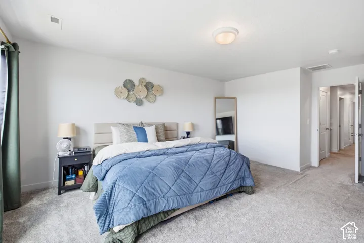 Carpeted bedroom with a flat white ceiling and light-colored walls
