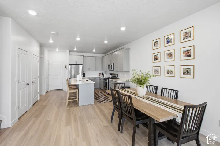 Open-concept living space featuring wood-finish flooring, recessed lighting, and a modern kitchen