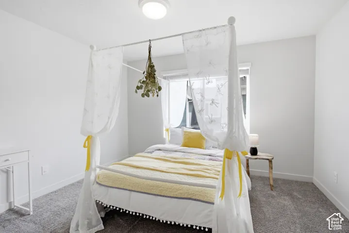 Recessed lighting fixture, neutral wall color, window with natural light, gray carpet flooring, and white baseboards
