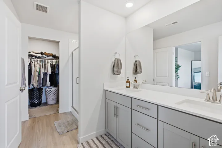 Dual sink vanity with light gray cabinetry and white countertops