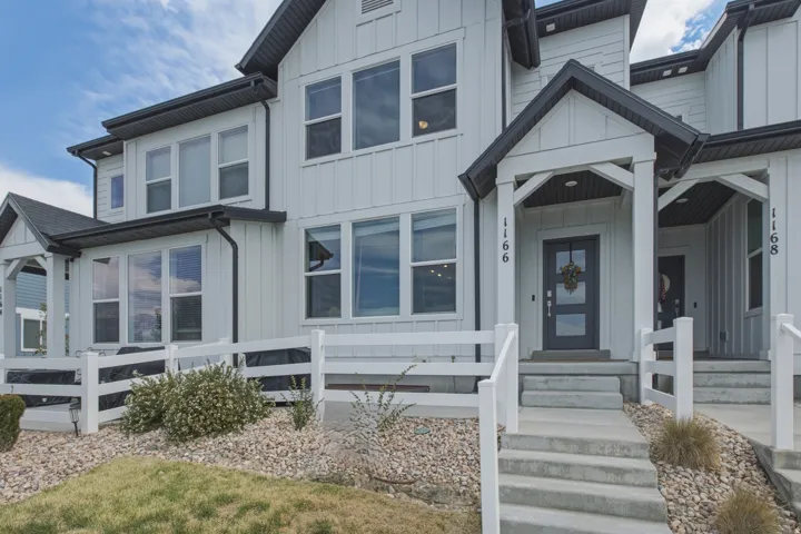 Modern farmhouse-style exterior with vertical white siding and dark trim