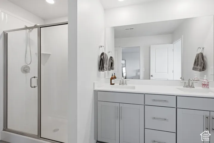 Double vanity with light gray cabinetry, brushed nickel hardware, and a white countertop