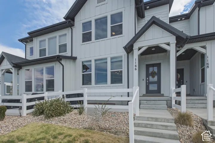 Modern farmhouse-style exterior with vertical white siding and dark trim
