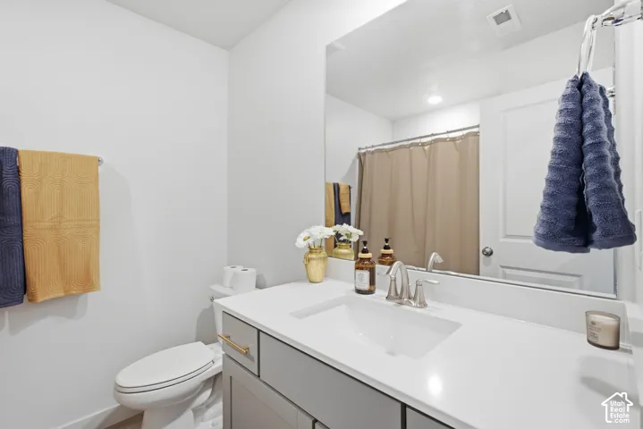Bathroom vanity featuring a rectangular undermount sink, brushed nickel faucet, and a light-toned countertop
