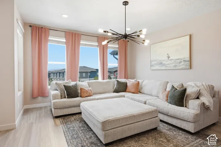 Living area featuring large windows, wood-finish flooring, and a modern sputnik chandelier