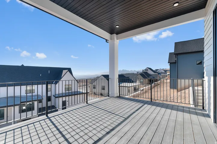 Covered outdoor deck with composite decking, black metal railings, and integrated ceiling lighting