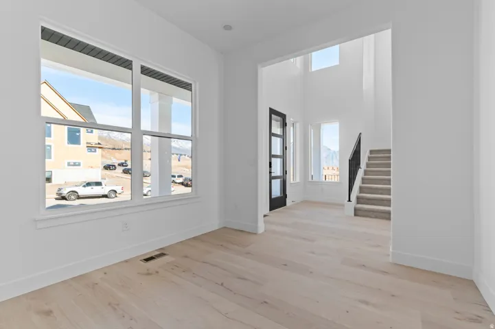 Open interior featuring light wood-finish flooring, white walls, and a large multi-pane window