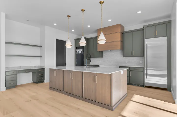 Contemporary kitchen featuring light wood-finish flooring and a central island with a light countertop