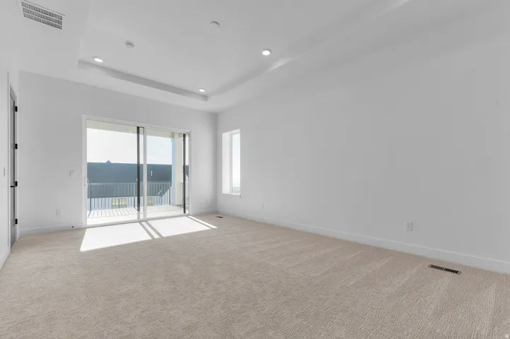 Spacious room featuring neutral carpet and abundant natural light