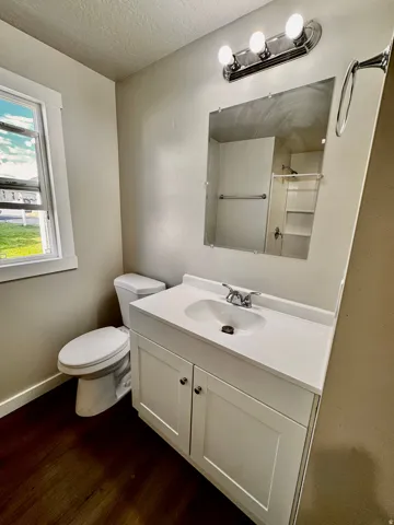 Bathroom featuring a white vanity with integrated sink, chrome faucet, and a large wall-mounted mirror