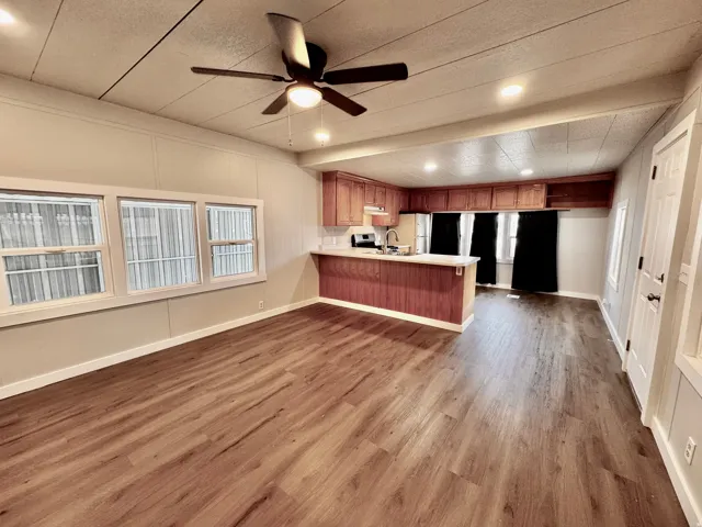 Open-concept living space featuring wood-finish flooring, recessed lighting, and a ceiling fan