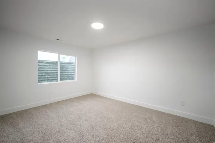 Neutral wall finishes, recessed lighting, and light-toned carpeting