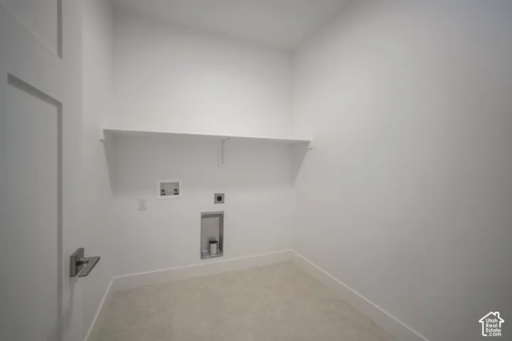 Dedicated utility space featuring a single floating shelf, durable tile flooring, and crisp white walls