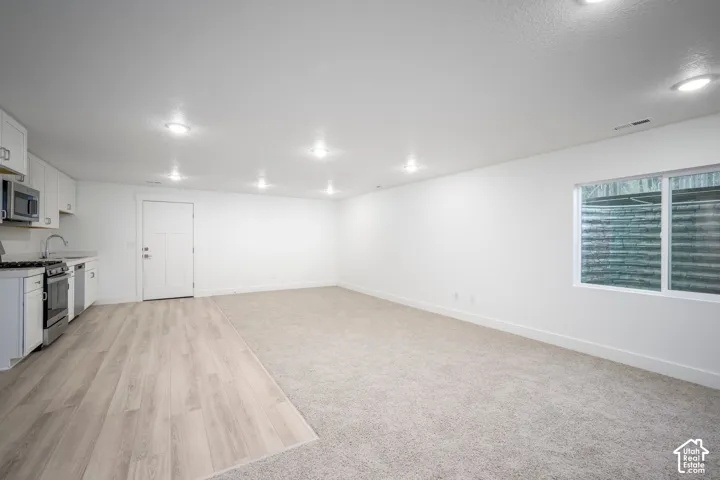 Open-concept living area featuring recessed lighting, a full kitchen, and a window