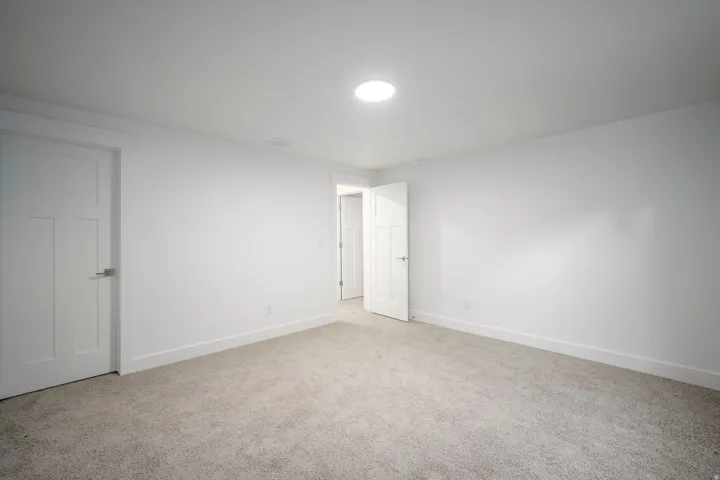 Carpeted interior space featuring white walls and white trim