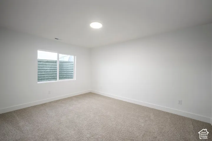 Neutral wall finishes, recessed lighting, and light-toned carpeting