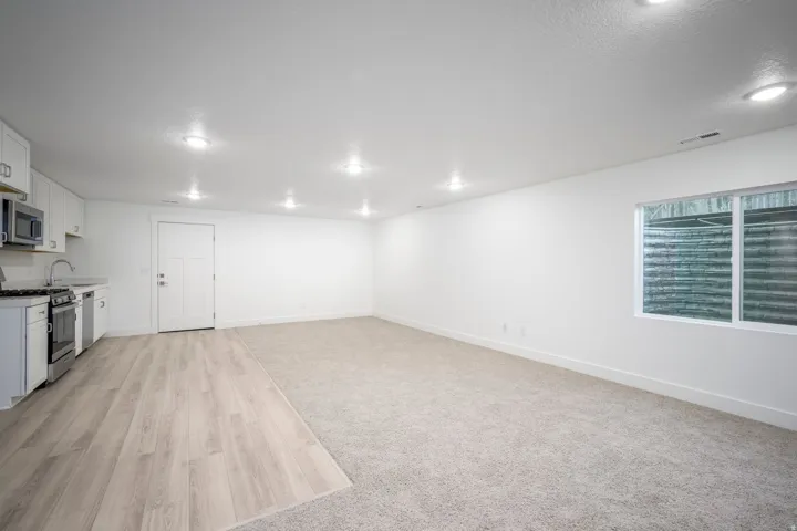 Open-concept living area featuring recessed lighting, a full kitchen, and a window