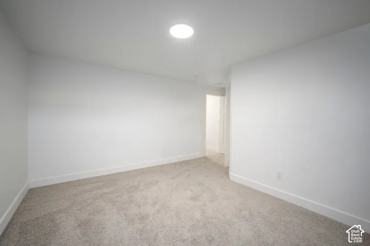 Carpeted room with white walls, white baseboards, and a circular ceiling light fixture