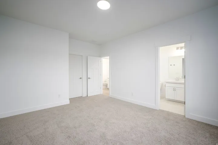 Carpeted interior space featuring white walls and baseboards