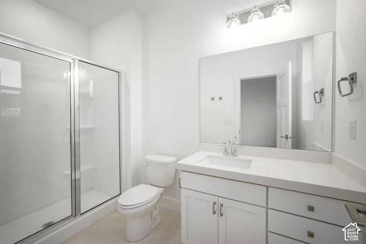 White vanity with a rectangular undermount sink, a chrome faucet, and a light-toned countertop